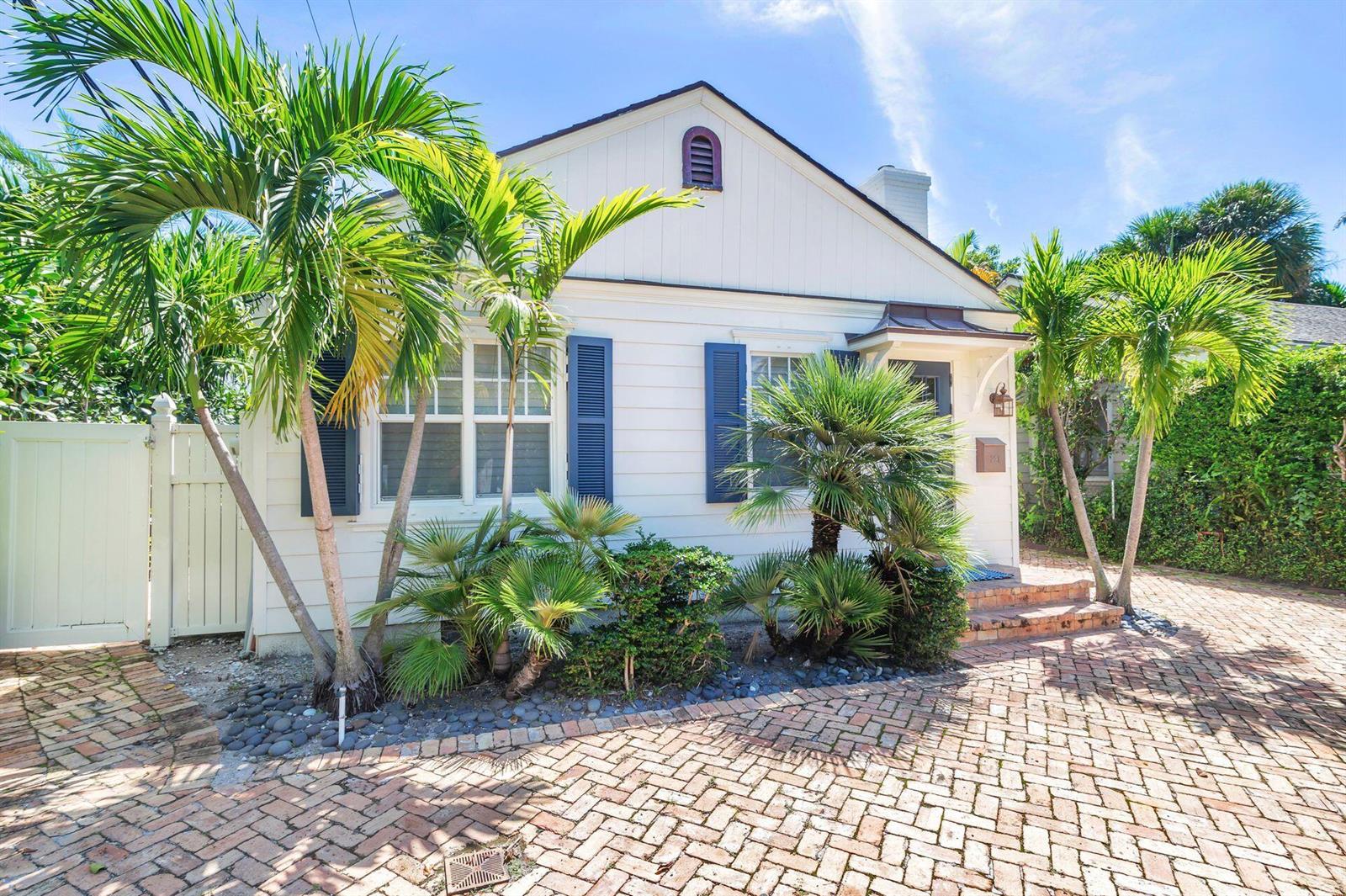 A white cottage with blue shutters, palm trees, and a brick driveway under a blue sky — 231 Cocoanut Row, Palm Beach FL 33480, PALM BEACH, FL
