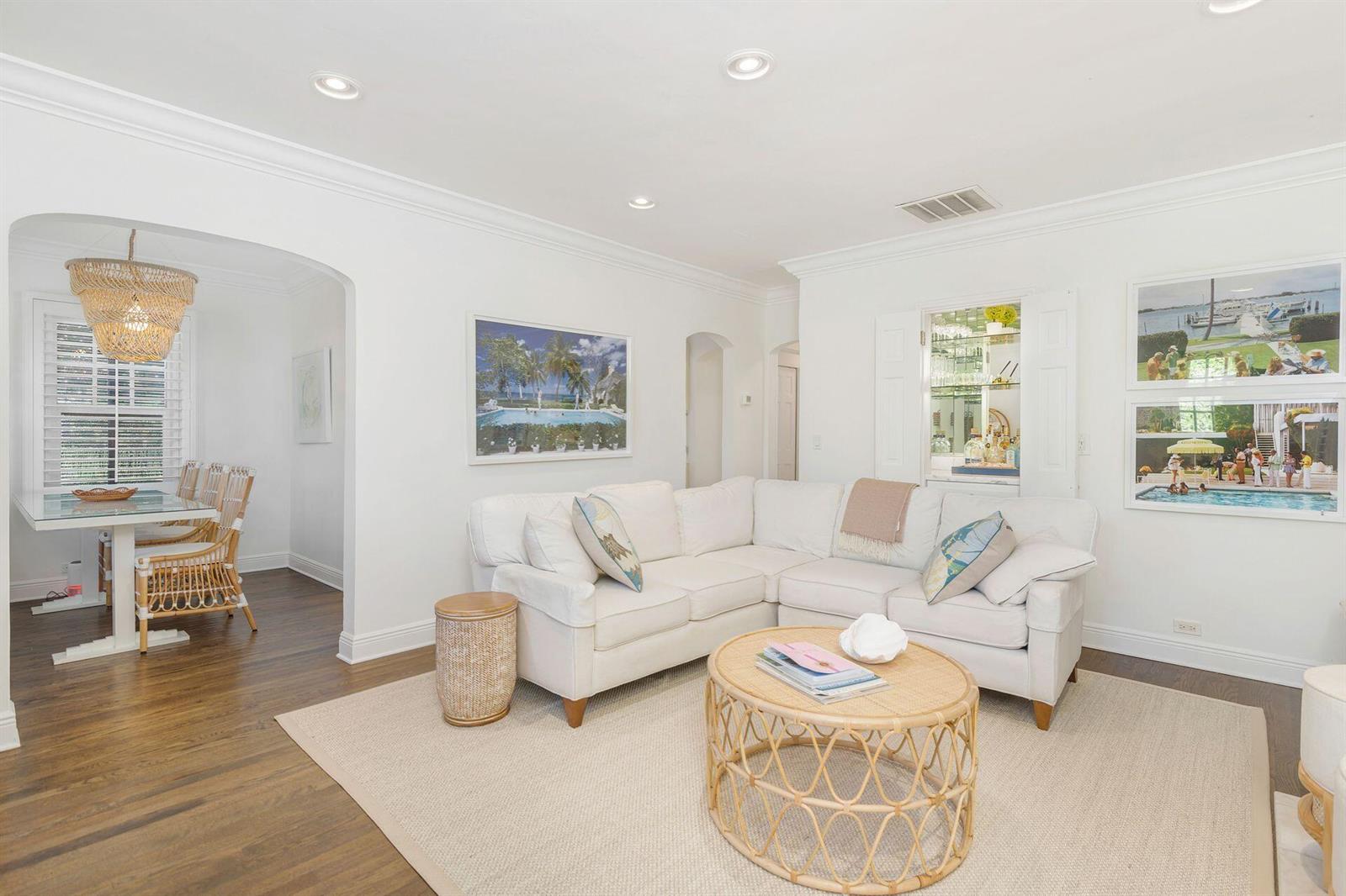 A living room with a white sectional sofa, a rattan coffee table, and an adjacent dining area — 231 Cocoanut Row, Palm Beach FL 33480, PALM BEACH, FL