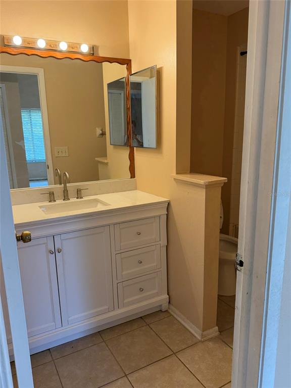 An empty room features beige walls, large floor tiles, and a window with vertical blinds — 6224 MISSON DRIVE, ORLANDO, FL