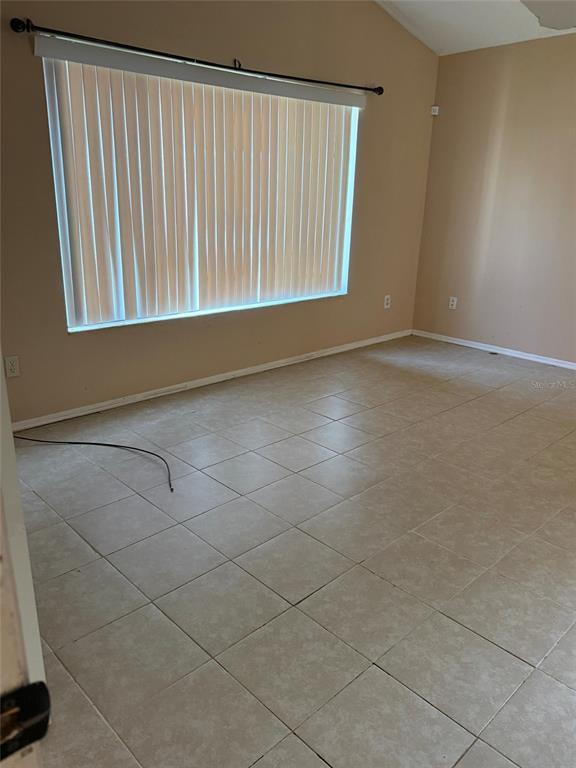 A walk-in shower with tan stone-look wall tiles and a white hexagonal tile floor — 6224 MISSON DRIVE, ORLANDO, FL