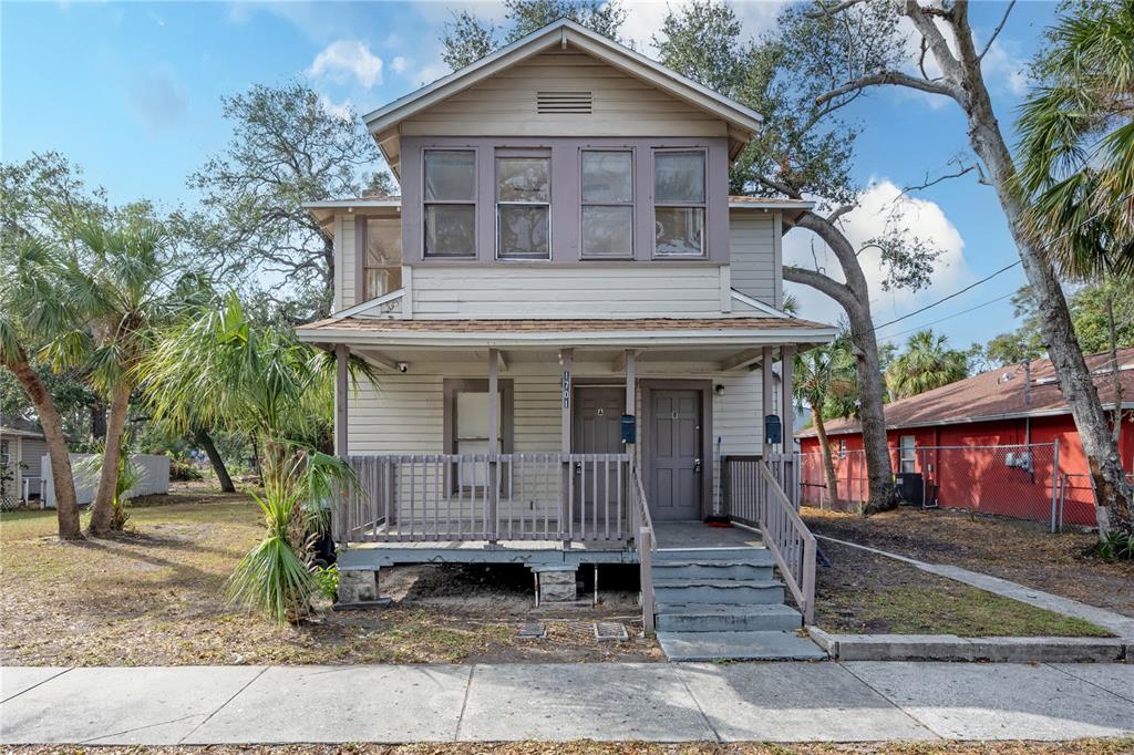 A two-story house with light siding, a front porch, and two entrance doors — 1701 S 14TH UNIT A, ST PETERSBURG, FL