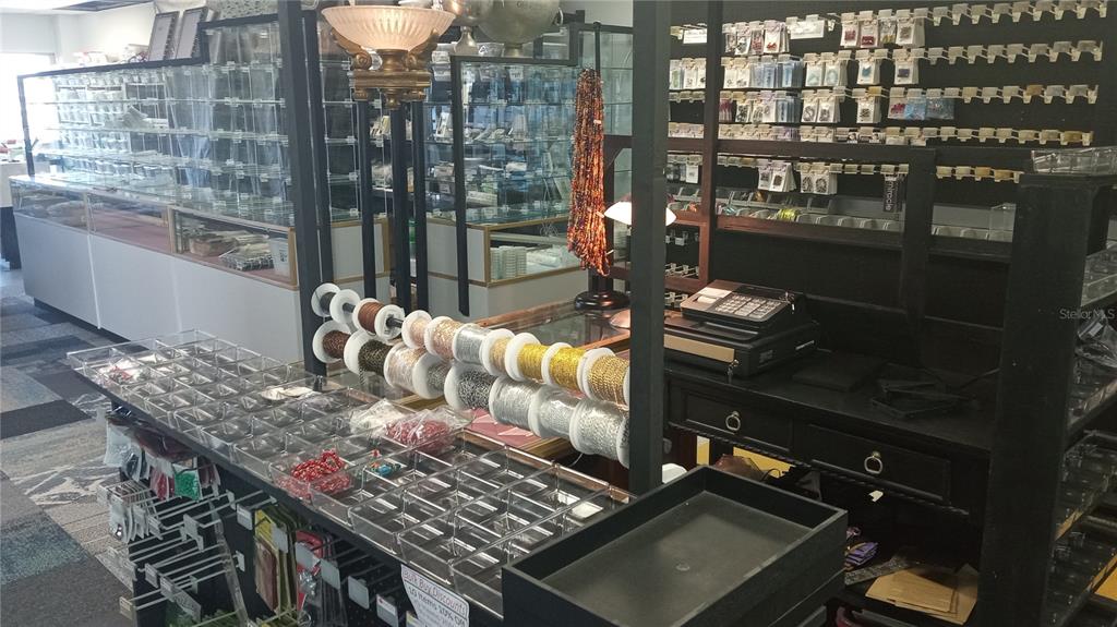 This retail store interior features glass display cases, organized jewelry supplies, and a checkout counter — 1460 S MCCALL ROAD UNIT 3F, ENGLEWOOD, FL