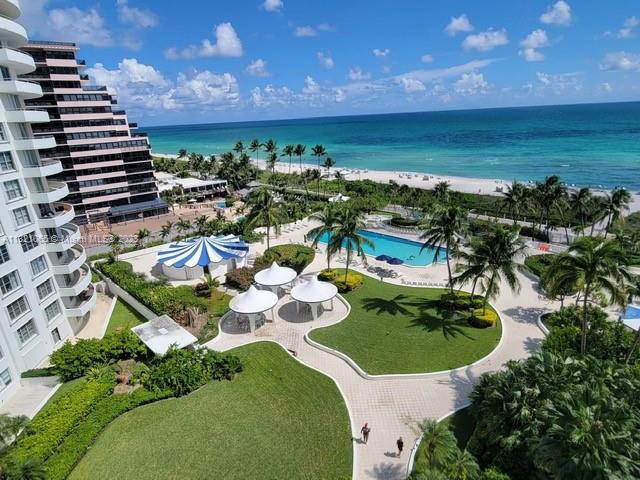 An elevated view shows a resort pool area, palm trees, and a beach along the ocean — 5151 Collins Ave # 1036, Miami Beach FL 33140, MIAMI BEACH, FL