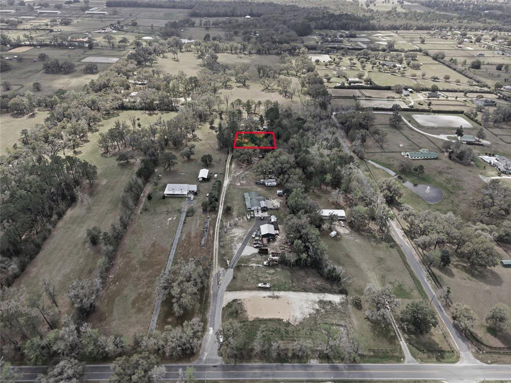 An aerial view shows a rural property with a red-outlined area amidst wooded land — 7900 W HIGHWAY 326, OCALA, FL