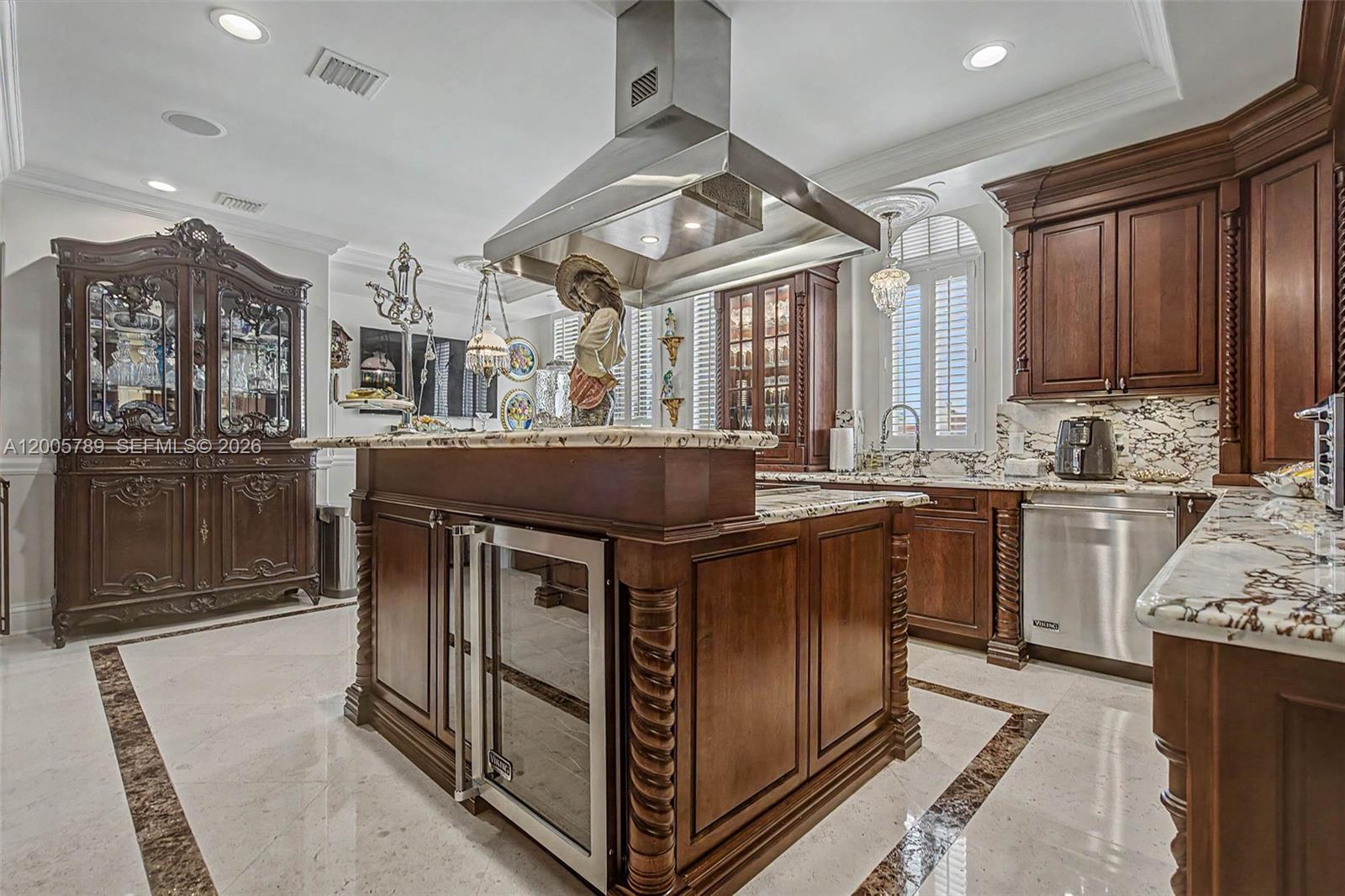 A traditional kitchen features dark wood cabinetry, marble countertops, a large island, and stainless appliances — 600 Coral Way # 5, Coral Gables FL 33134, CORAL GABLES, FL