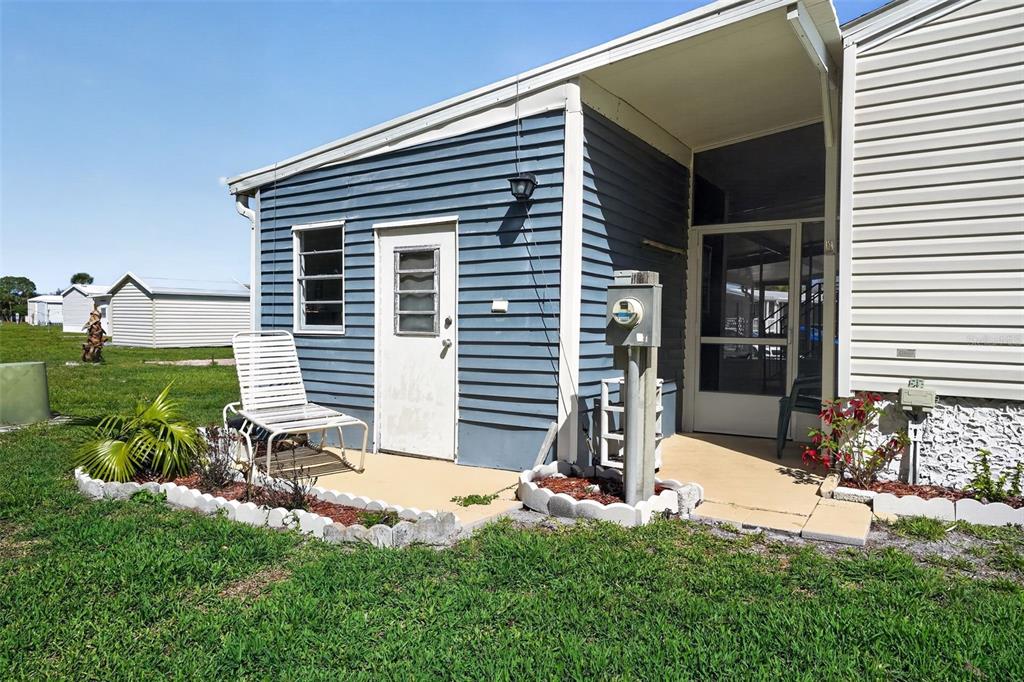 The exterior of a mobile home features blue siding, a white door, and a screened porch — 132 HOLIDAY PARK BOULEVARD NE, PALM BAY, FL