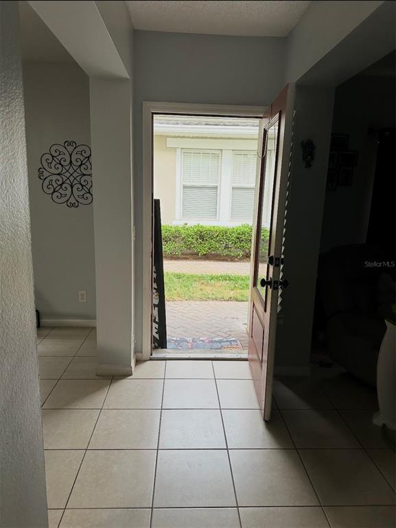 A two-story house exterior features a garage, a front porch, and a manicured hedge — 2048 CYPRESS BAY BOULEVARD, KISSIMMEE, FL