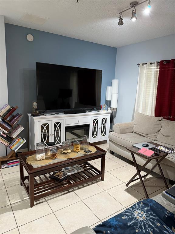 A room with light-colored tile flooring, a ceiling fan, and a door leading outside — 2048 CYPRESS BAY BOULEVARD, KISSIMMEE, FL