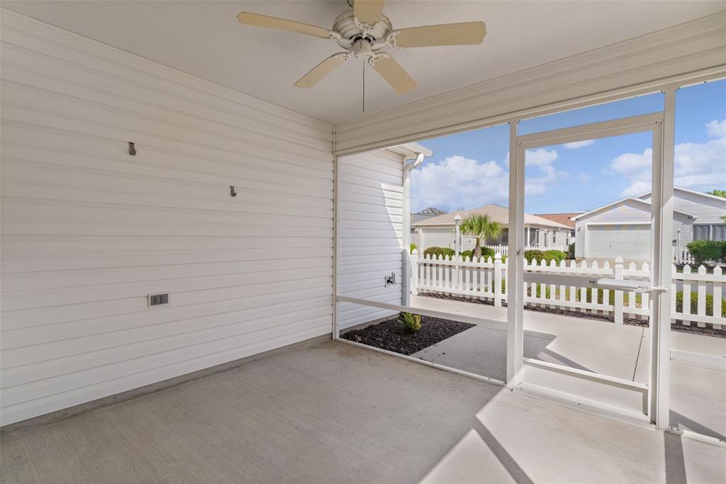 A screened-in porch with a ceiling fan, concrete floor, and white vinyl siding — 1838 ENDSLEY COURT, THE VILLAGES, FL
