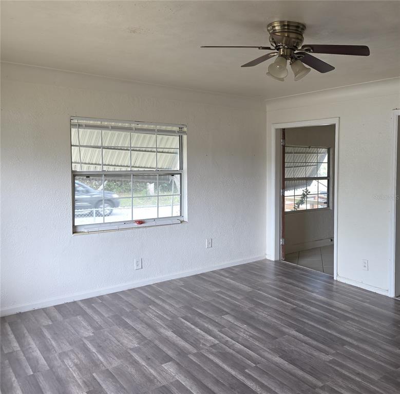 A room with white walls, gray wood-look flooring, a ceiling fan, and two windows — 1800 22ND AVENUE S, ST PETERSBURG, FL
