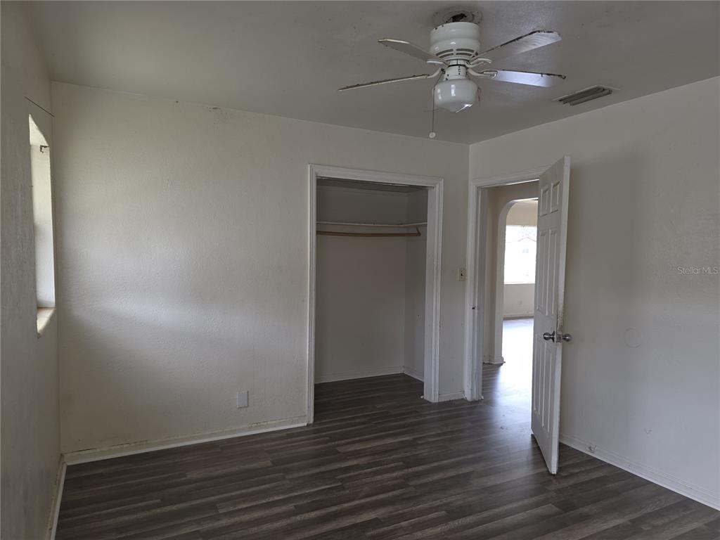 An empty bedroom features white walls, wood-look flooring, a ceiling fan, and a closet — 1800 22ND AVENUE S, ST PETERSBURG, FL