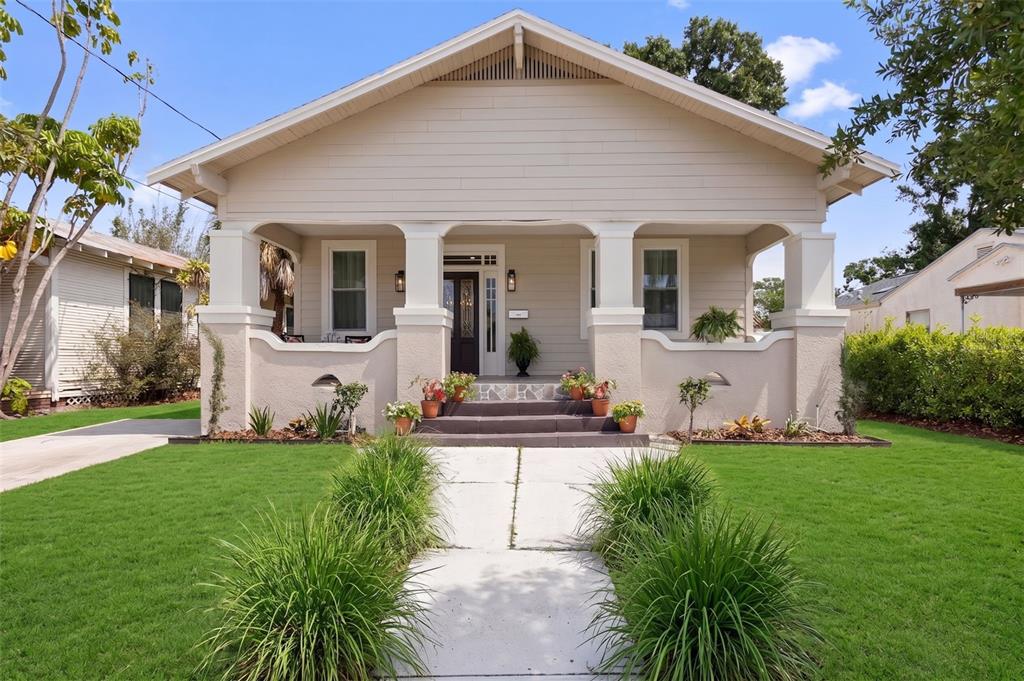 A tan bungalow house features a covered front porch with columns and a concrete walkway — 1917 W LEMON STREET, TAMPA, FL