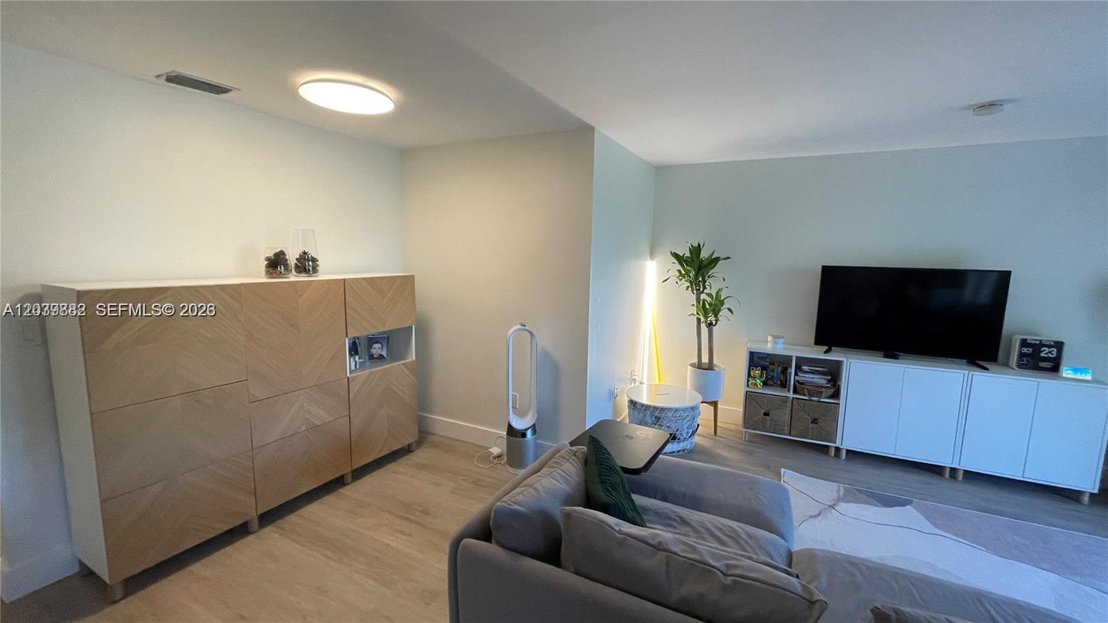 A living room features a grey sectional sofa, a wooden cabinet, and a television console — 8480 SW 154th Cir Ct # 920, Miami FL 33193, MIAMI, FL
