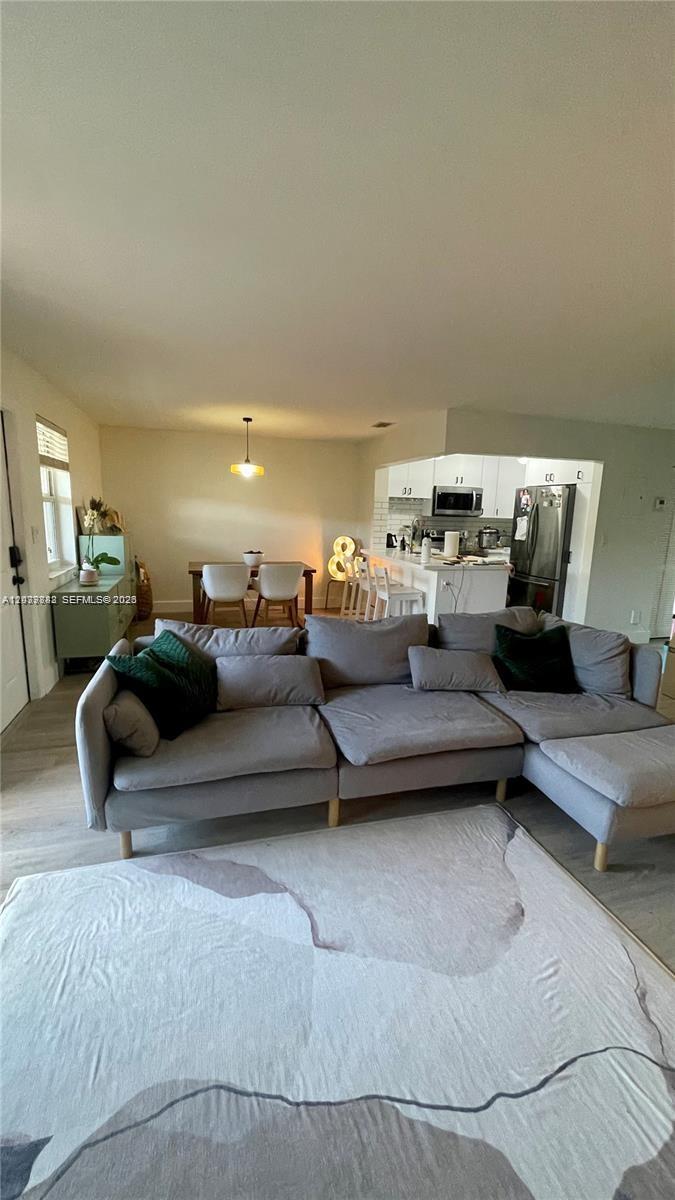 A living room with a large grey sectional sofa, a dining area, and an open kitchen — 8480 SW 154th Cir Ct # 920, Miami FL 33193, MIAMI, FL