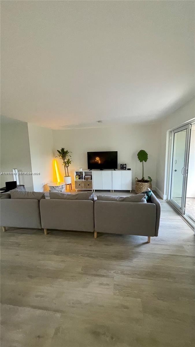 A living room features a gray sectional sofa, a white media console, and light wood flooring — 8480 SW 154th Cir Ct # 920, Miami FL 33193, MIAMI, FL
