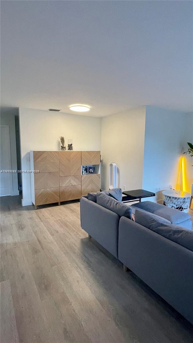 A living room features light wood flooring, a chevron-patterned storage cabinet, and a gray sofa — 8480 SW 154th Cir Ct # 920, Miami FL 33193, MIAMI, FL