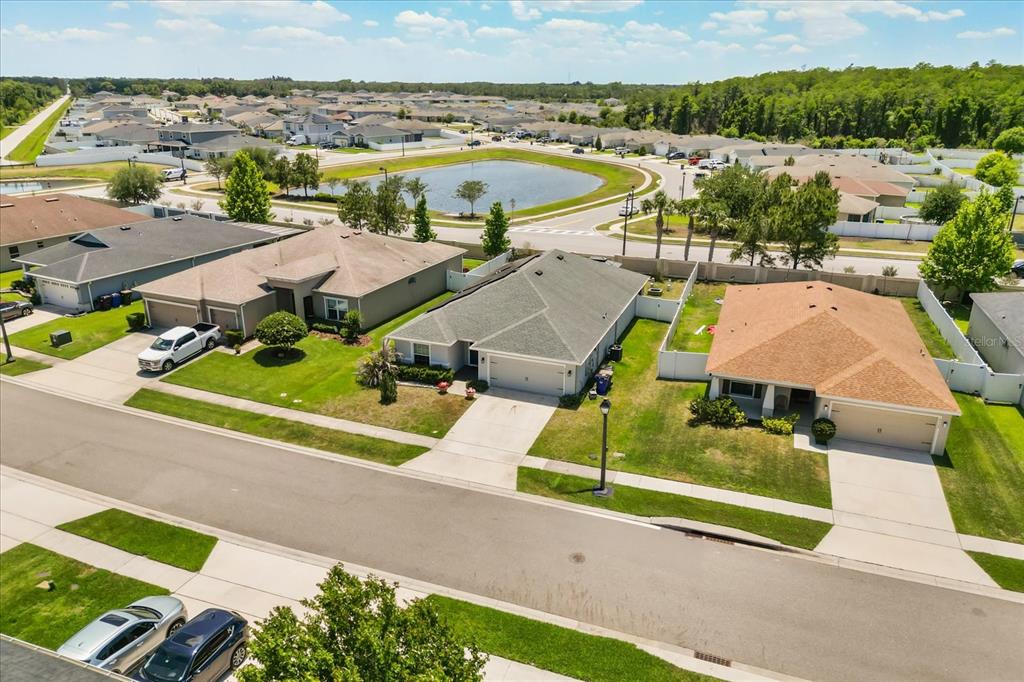An open-concept kitchen and living area features a large island, gray cabinetry, and wood flooring — 4531 CALUMET DRIVE, ST CLOUD, FL