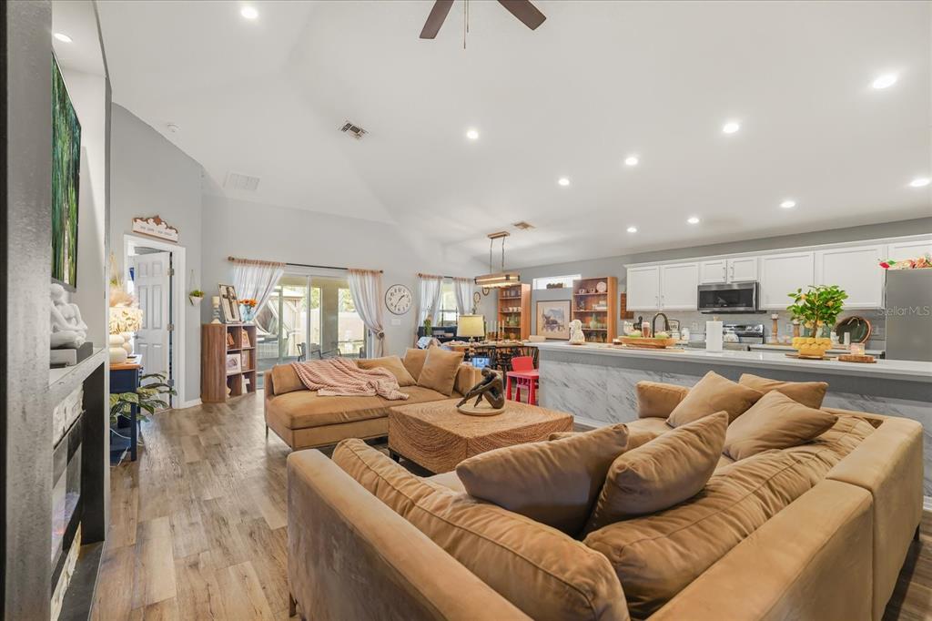 A bedroom features a bed with a beige headboard, a ceiling fan, and a window — 4531 CALUMET DRIVE, ST CLOUD, FL