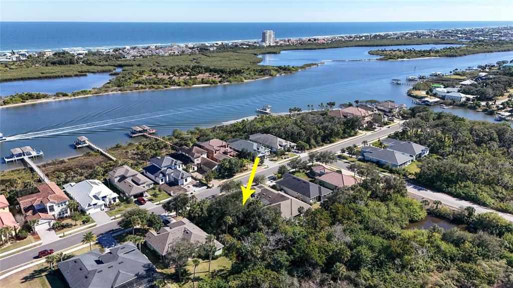 An aerial view shows a residential neighborhood near a waterway with a yellow arrow pointing down — 284 S RIVERWALK DRIVE, PALM COAST, FL