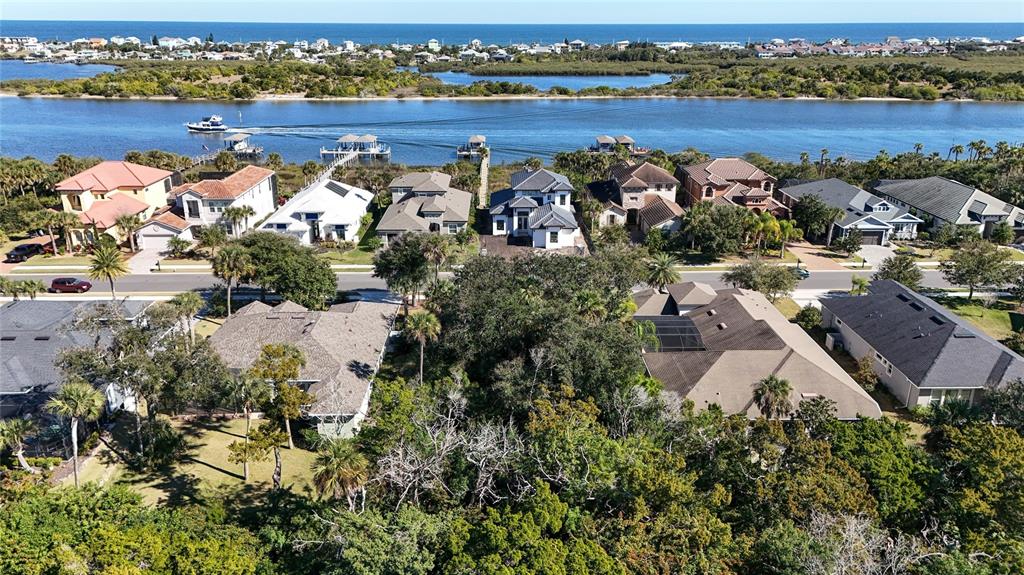 An aerial view shows waterfront homes with docks along a canal near the ocean — 284 S RIVERWALK DRIVE, PALM COAST, FL