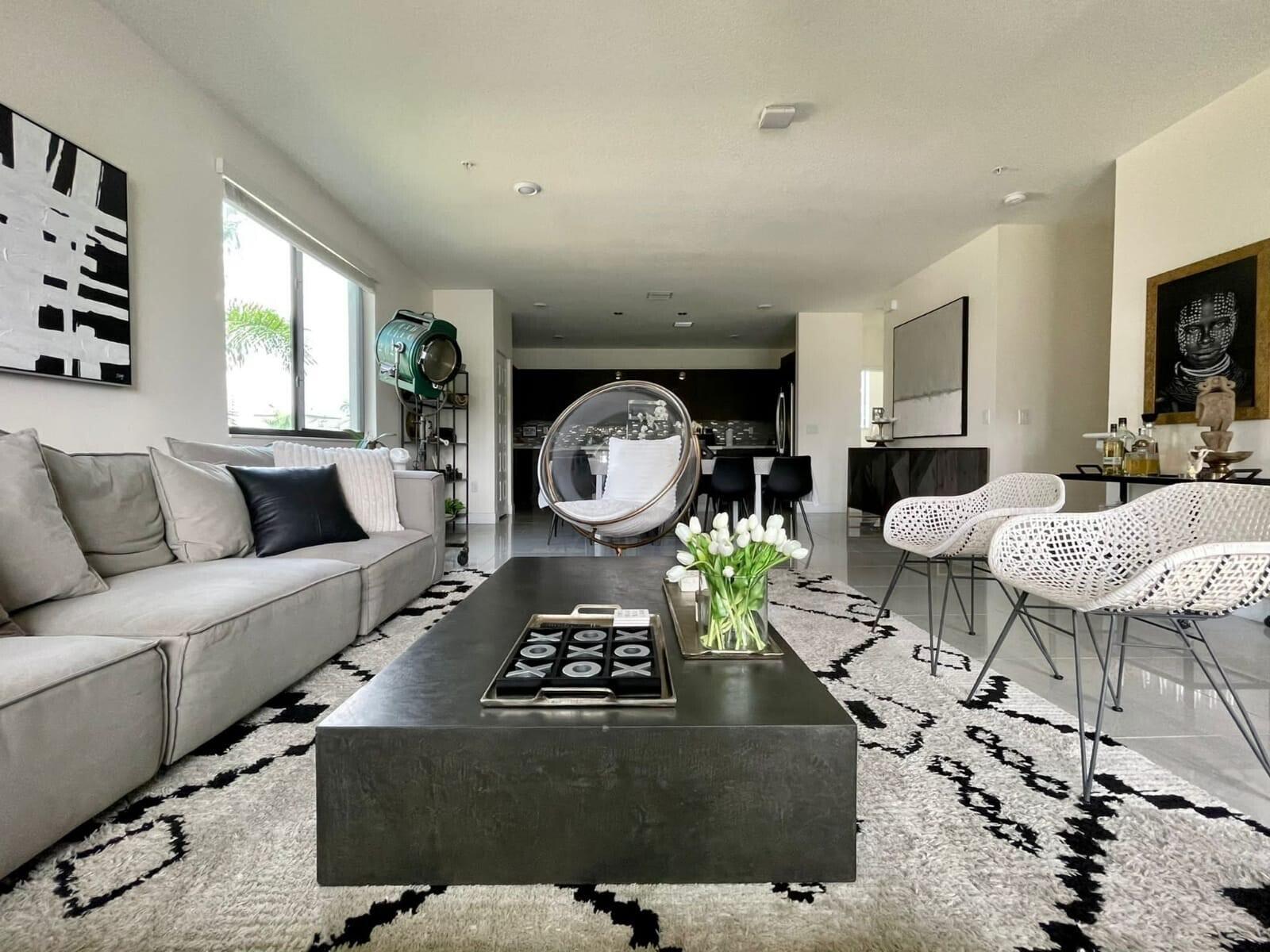 A modern living room features a large grey sofa, a black coffee table, and a bubble chair — 4713 NW 84th Court, Doral FL 33166, DORAL, FL