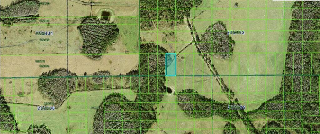 This aerial map shows a rectangular parcel of land highlighted in blue within a rural area — COMMONWEALTH AVE N, POLK CITY, FL