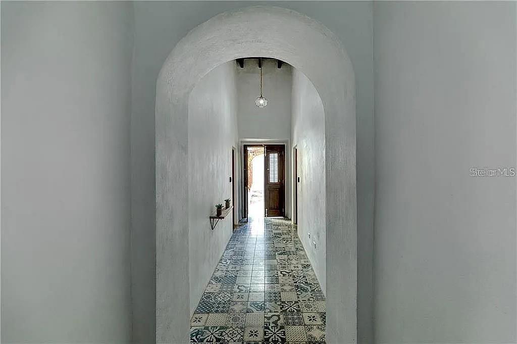 A hallway with an arched entryway features patterned tile flooring and a hanging pendant light — 259 & 261 CALLE DE SAN SEBASTIAN, SAN JUAN, PR
