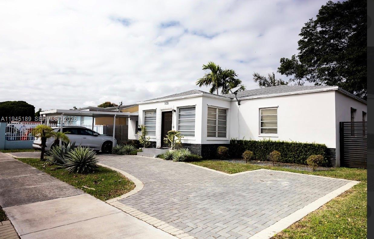 A white single-story house with a paved driveway and a metal carport — 3135 NW 18th St, Miami FL 33125, MIAMI, FL