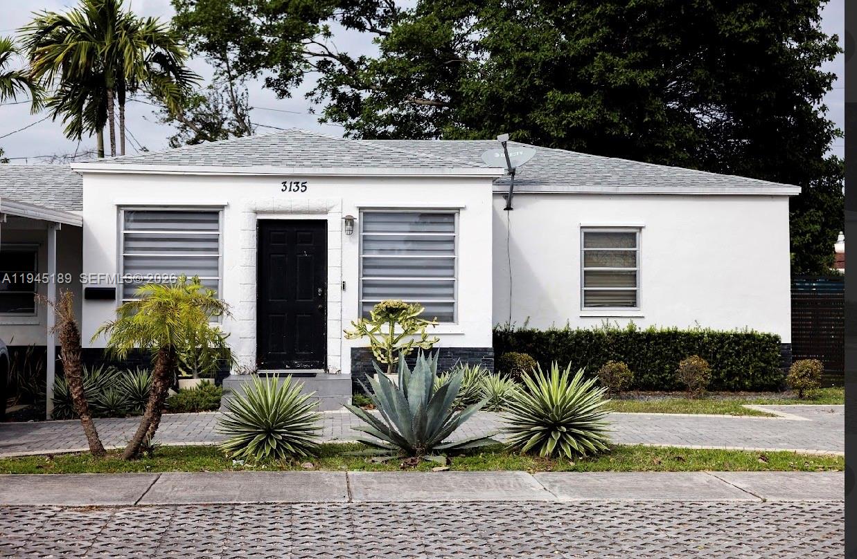 A single-story white house with a black front door and horizontal window blinds — 3135 NW 18th St, Miami FL 33125, MIAMI, FL