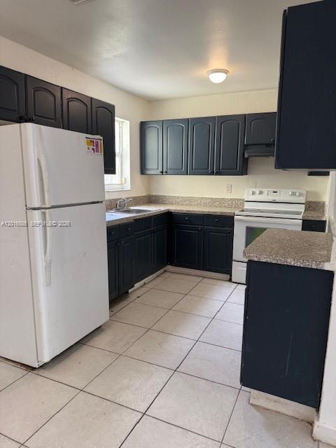 A kitchen features dark cabinets, a white refrigerator, a white stove, and light-colored floor tiles — 1766 NW 34TH AVENUE, Lauderhill FL 33311, LAUDERHILL, FL