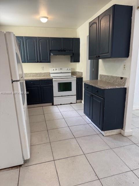 A kitchen features dark blue cabinets, light countertops, a white stove, and tiled flooring — 1766 NW 34TH AVENUE, Lauderhill FL 33311, LAUDERHILL, FL