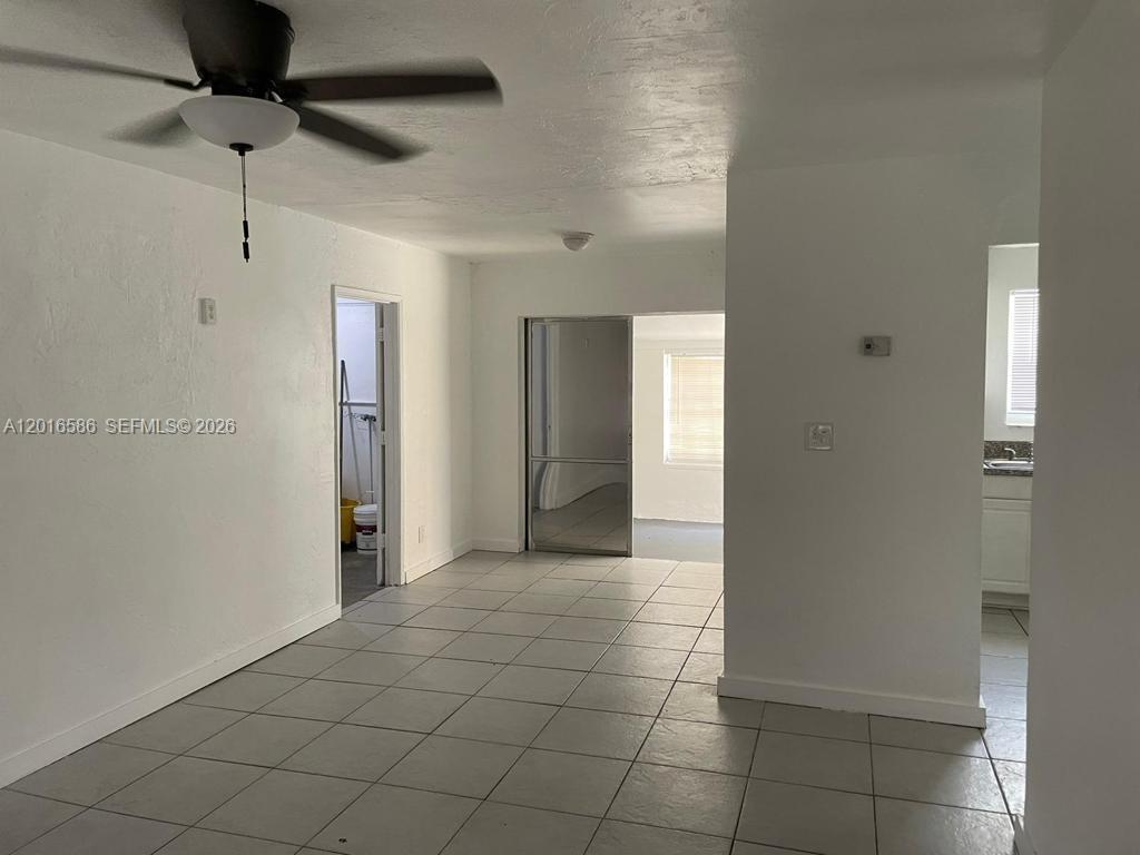 A room with white walls, light-colored tile flooring, a ceiling fan, and multiple doorways — 1766 NW 34TH AVENUE, Lauderhill FL 33311, LAUDERHILL, FL