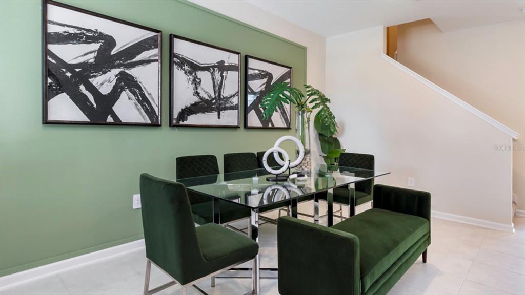A dining room features a glass table, green velvet chairs, and three abstract wall prints — 5844 ENERGY WAY, CLERMONT, FL