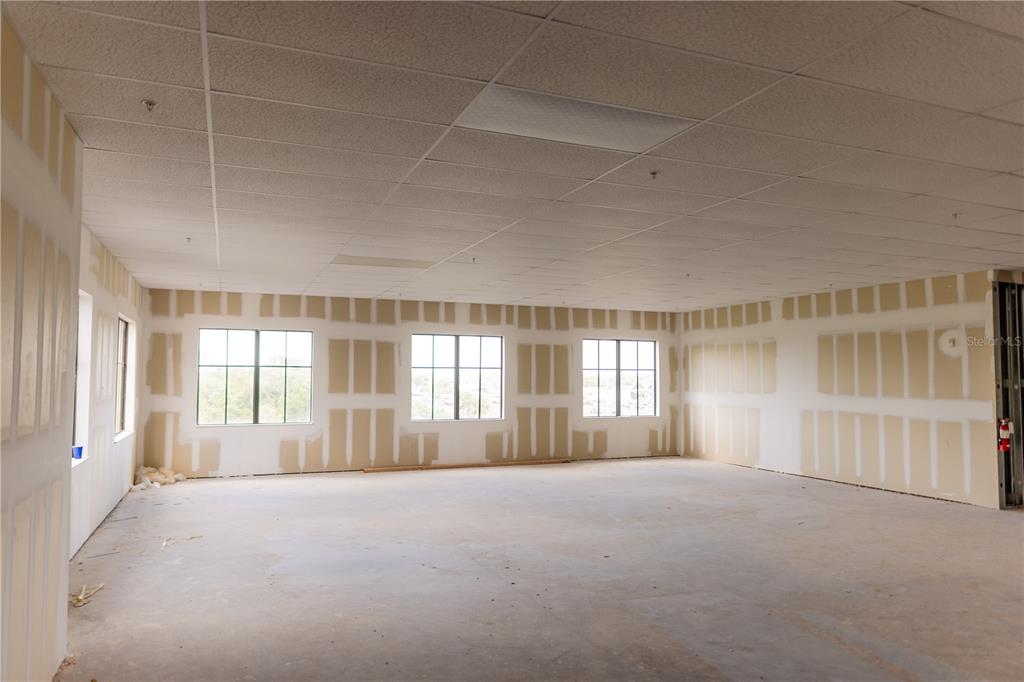 An unfinished commercial office space features drywall walls, a drop ceiling, and large windows — 5920 PAN AMERICAN BOULEVARD UNIT 310, NORTH PORT, FL