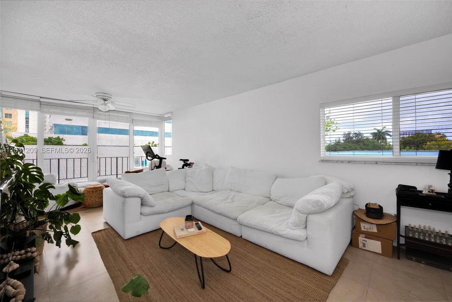 A living room features a white sectional sofa, a wooden coffee table, and large windows — 2539 S Bayshore Dr, Coconut Grove FL 33133, COCONUT GROVE, FL