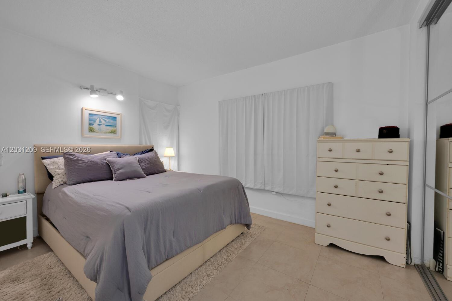 A bedroom features a bed with a gray comforter, a dresser, and tile flooring — 2539 S Bayshore Dr, Coconut Grove FL 33133, COCONUT GROVE, FL