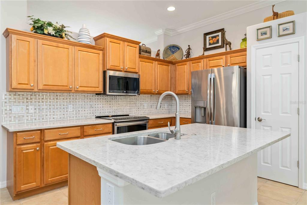 A bright, open-concept living and dining area features tile flooring, neutral furniture, and large windows — 8150 INDIGO RIDGE TERRACE, UNIVERSITY PARK, FL