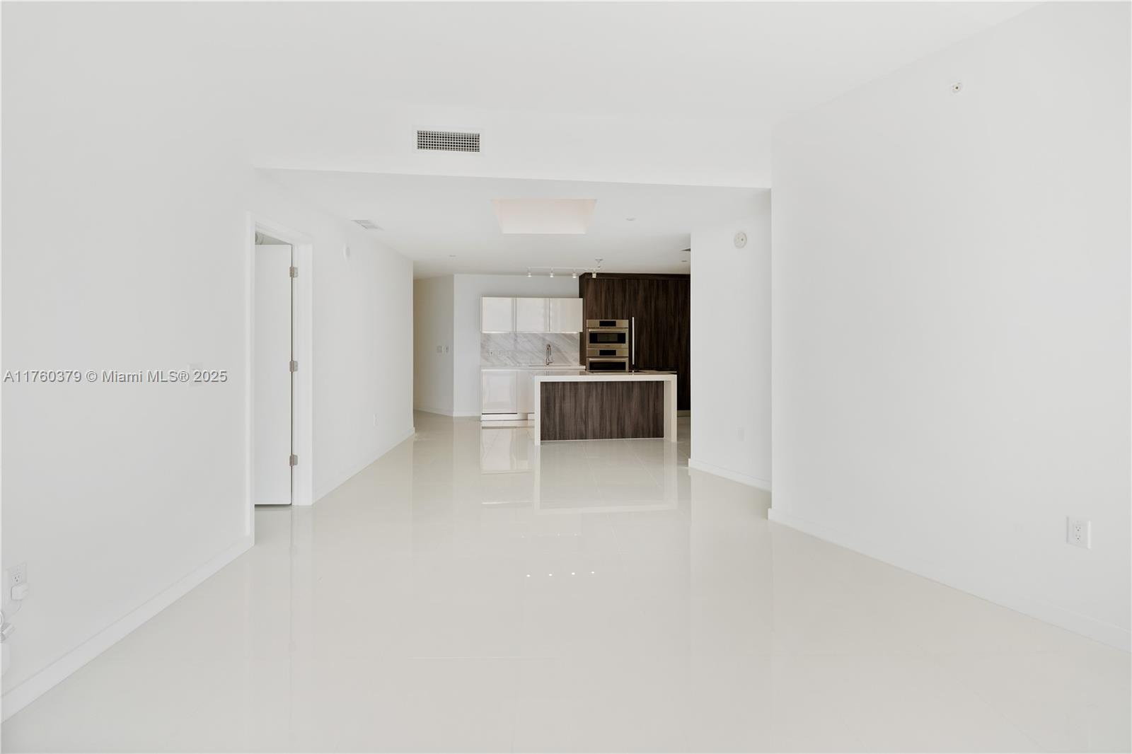 An open-concept kitchen with a central island and white tile flooring in a modern apartment — 851 NE 1st Ave # 4203, Miami FL 33132, MIAMI, FL