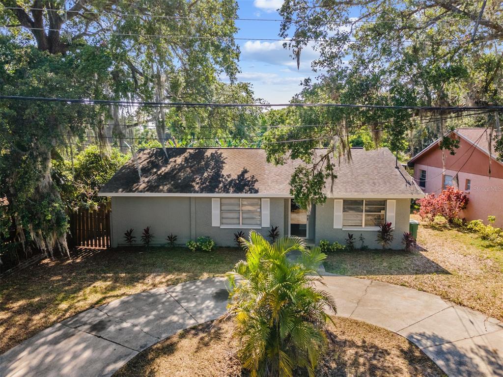 A single-story gray house with a shingled roof and a curved concrete driveway — 9616 N OKLAWAHA AVENUE UNIT 1/2, TAMPA, FL