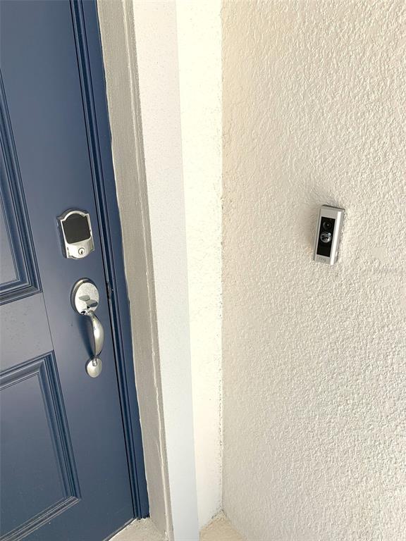 A blue front door with a smart lock and a Ring doorbell on the wall — 1374 BRENTWOOD DRIVE, KISSIMMEE, FL
