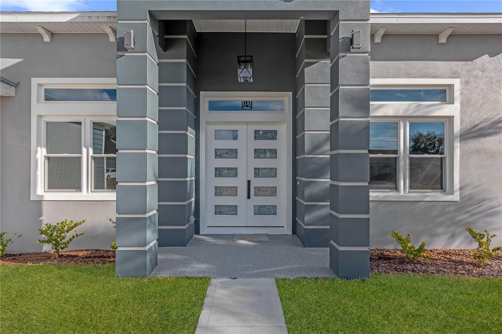 The exterior of a house features a double front door with glass panels and columns — 28 BUFFALO BILL DRIVE, PALM COAST, FL