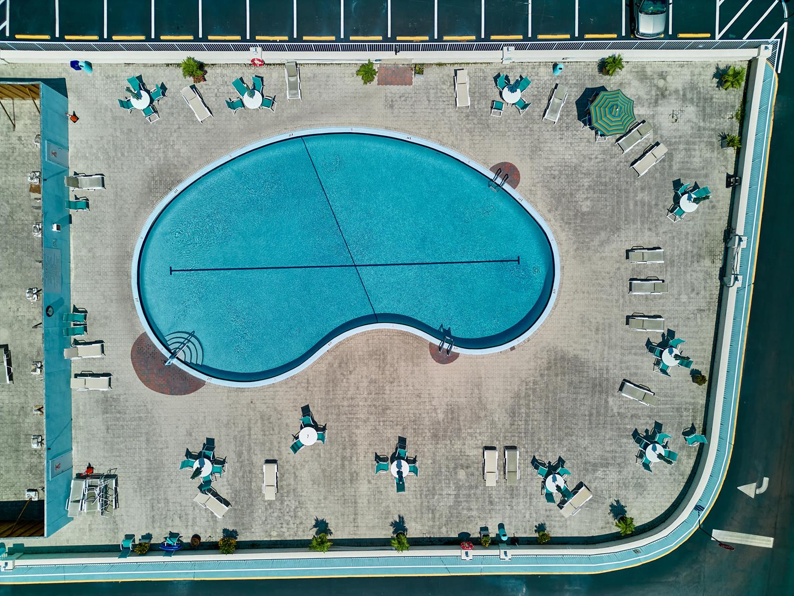 An aerial view shows a kidney-shaped swimming pool surrounded by lounge chairs and patio tables — 880 Horizons W # 102, Boynton Beach FL 33435, BOYNTON BEACH, FL