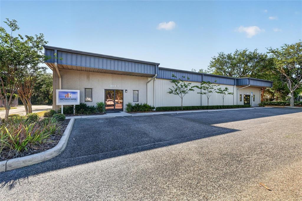 A single-story commercial building with a gray metal roof and a paved parking lot — 304 RICHEY ROAD UNIT 1, LEESBURG, FL