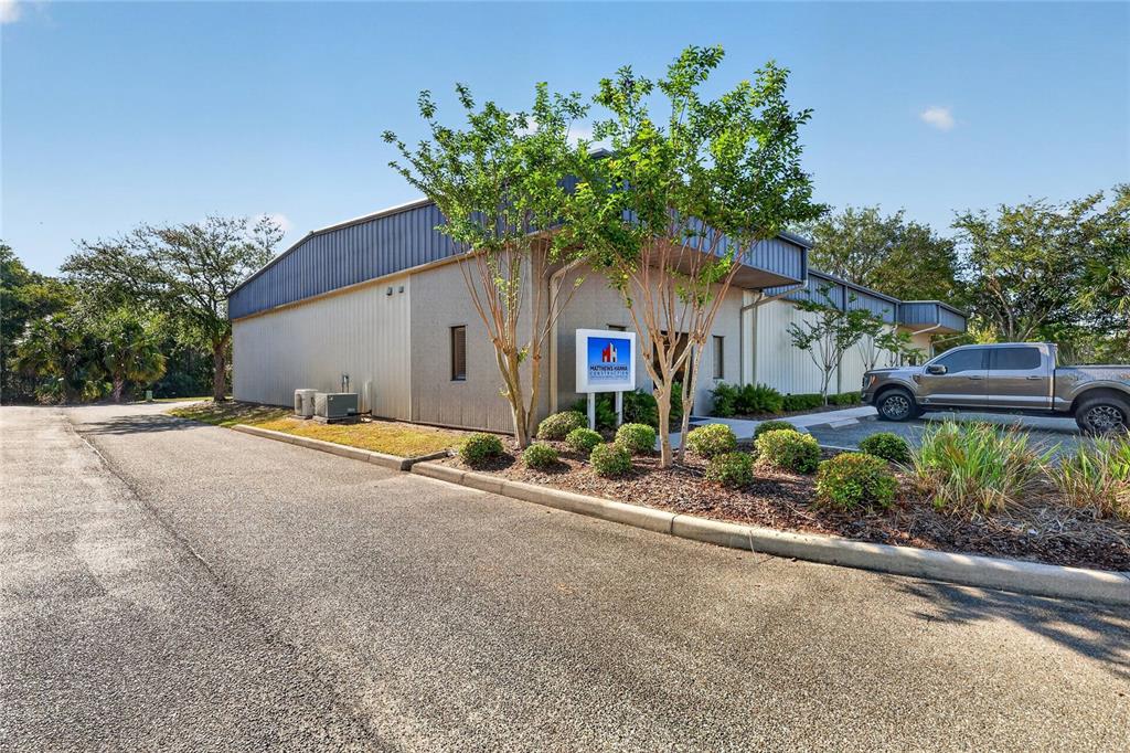 A single-story commercial building with a metal roof, tan siding, and a parking lot — 304 RICHEY ROAD UNIT 1, LEESBURG, FL