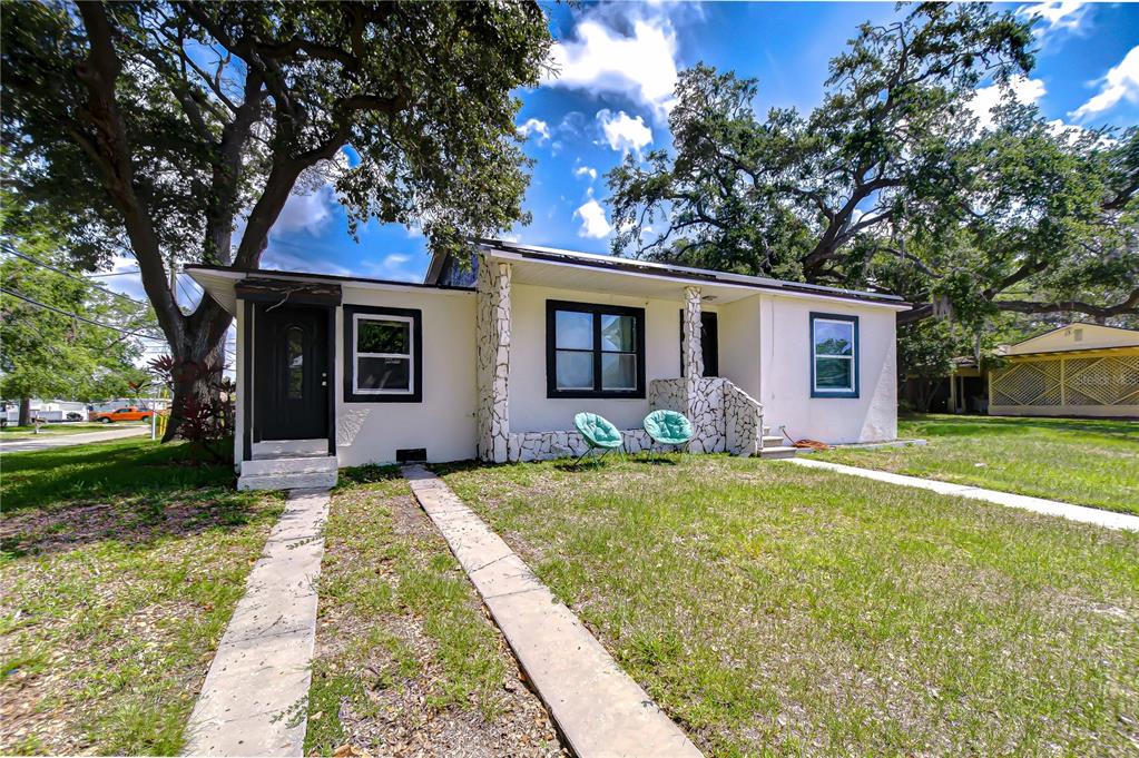 A single-story house with white stucco walls, stone accents, and a black front door — 5325 8TH AVENUE S, GULFPORT, FL