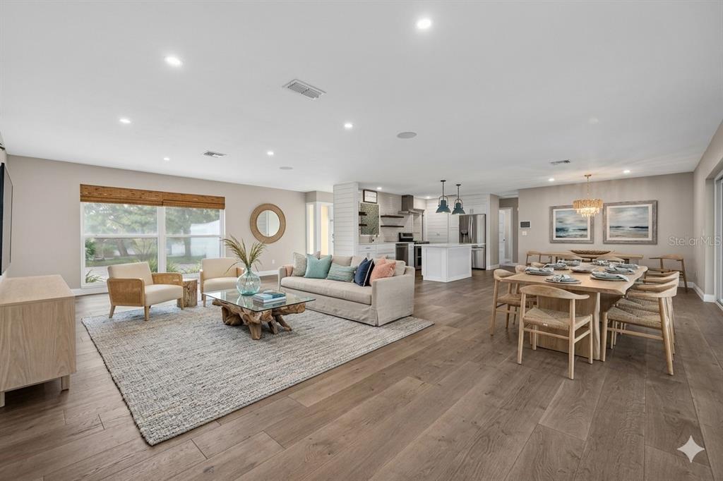An open-concept living and dining area features light wood floors, recessed lighting, and neutral decor — 4200 BEACH DRIVE SE, ST PETERSBURG, FL