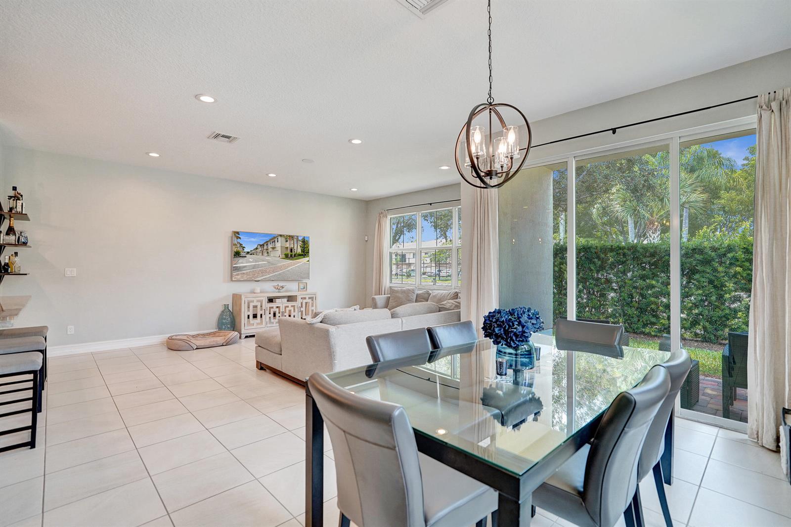A dining area with a glass table and a living room with a sectional sofa — 99 Palm Lane, Royal Palm Beach FL 33411, ROYAL PALM BEACH, FL