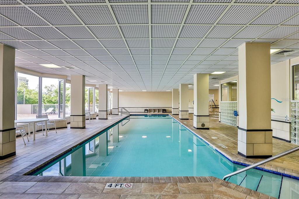 An indoor swimming pool with tiled flooring, support columns, and a drop ceiling — 3 OCEANS WEST BOULEVARD UNIT 7C1, DAYTONA BEACH, FL