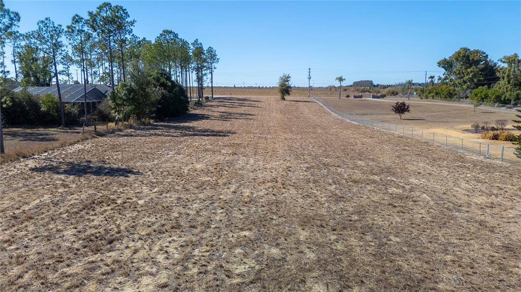 An aerial view of a large, dry, grassy vacant lot bordered by trees and fencing — 0 S SCENIC HWY, LAKE WALES, FL