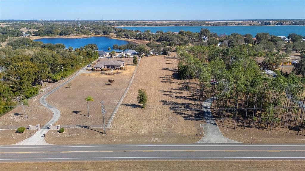 An aerial view shows a large, grassy lot with a house and driveway near water — 0 S SCENIC HWY, LAKE WALES, FL